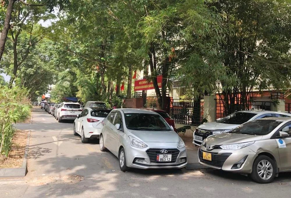 Vỉa hè trước cổng Sở TN&amp;MT Hà Nội bị biến thành bãi đỗ xe ô tô. Ảnh: TP