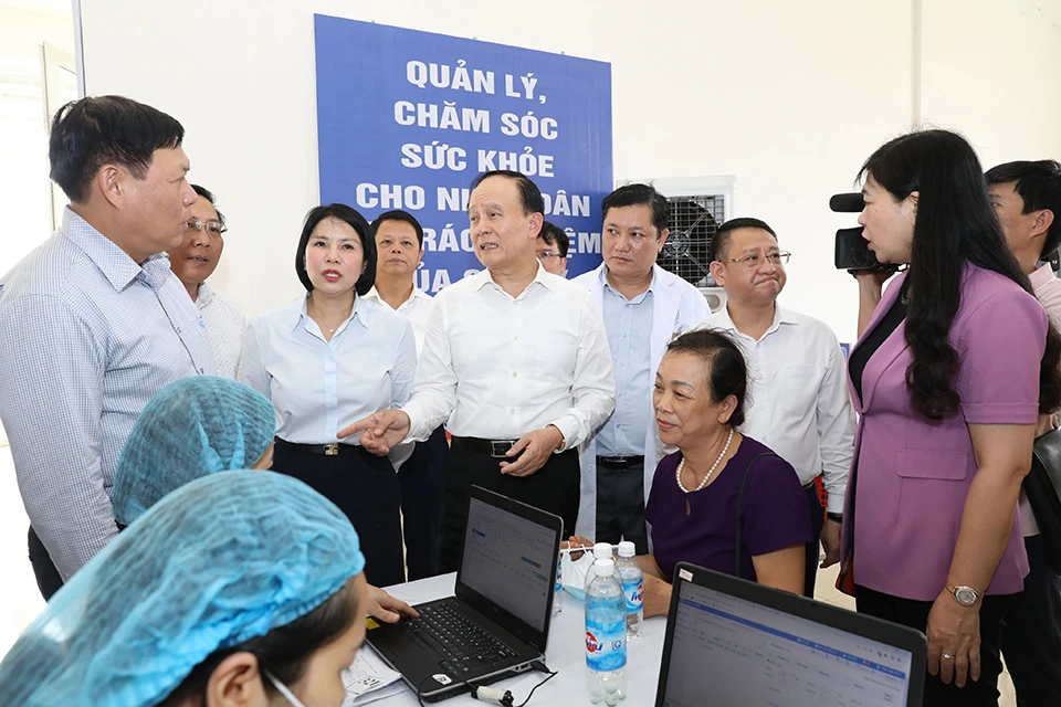 Chủ tịch HĐND TP Hà Nội Nguyễn Ngọc Tuấn trao đổi với Thứ trưởng Bộ Y tế Đỗ Xuân Tuyên về công tác tổ chức khám, lập hồ sơ sức khoẻ điện tử cho bà con huyện Mê Linh (Ảnh: TP)