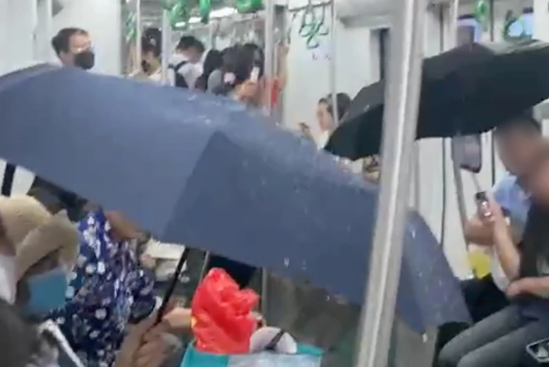 Trên một đoàn tàu đường sắt trên cao tuyến Cát Linh - Hà Đông (Metro Cát Linh - Hà Đông) bị dột nước khiến nhiều hành khách phải che ô và di chuyển khỏi khu vực có nước chảy. Ảnh cắt từ clip