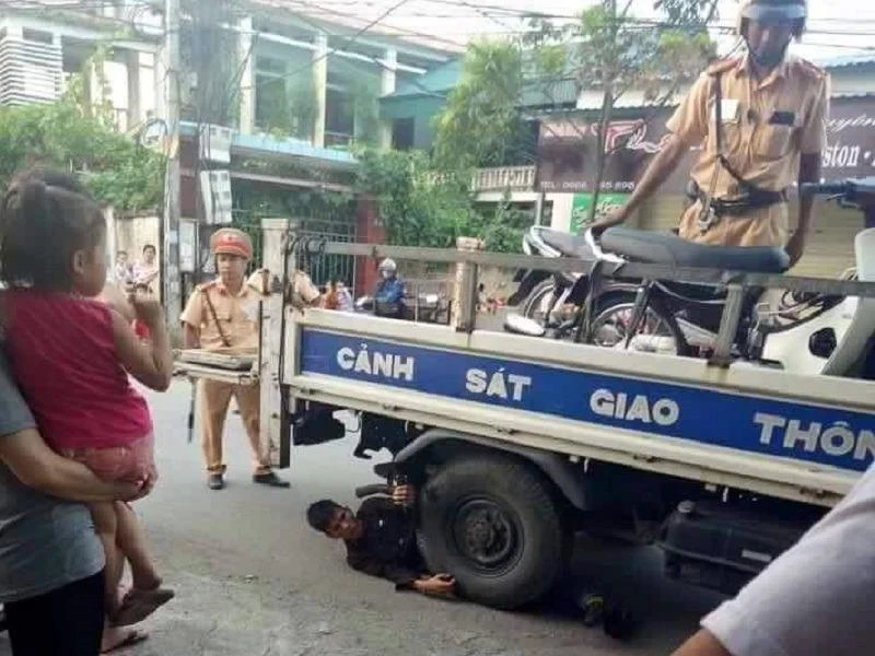 Nam thanh niên nằm dưới bánh xe của CSGT để "ăn vạ". 