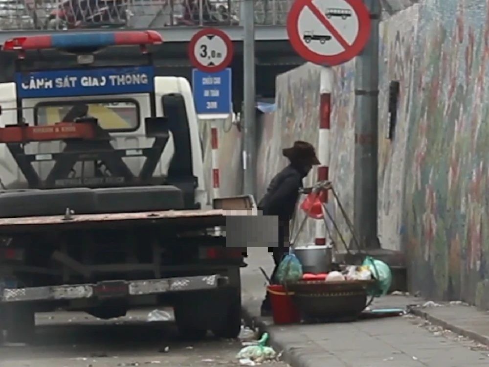 Một phụ nữ bán hàng rong vô tư tè bậy tại khu vực gầm cầu Long Biên.