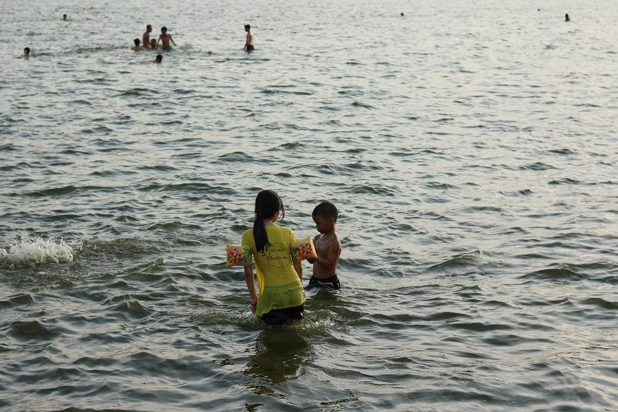 Anh Phạm Minh sống gần hồ Tây dẫn con đến bơi chia sẻ: “Nước chỉ sâu đến eo của mình, hè thỉnh thoảng cho các con ra chơi và tập bơi. Nước ở đoạn này không bẩn mà mát lắm”.