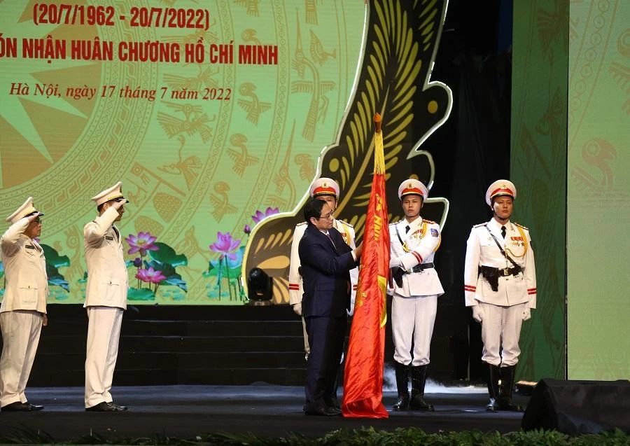 Thủ tướng Phạm Minh Chính gắn Huân chương Hồ Chí Minh lên Cờ truyền thống của lực lượng Cảnh sát nhân dân. Ảnh: UYÊN TRANG