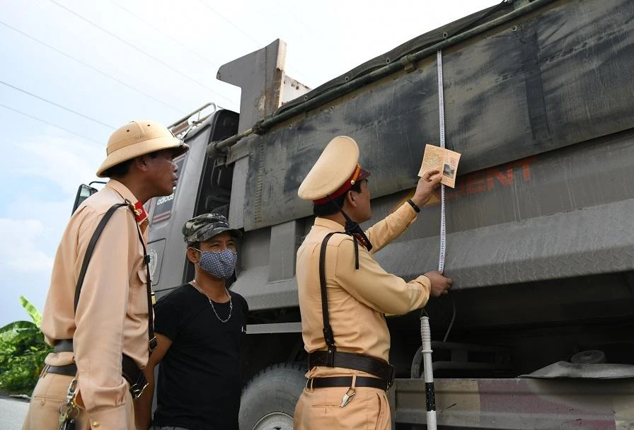 CSGT kiểm tra kích thước thùng một xe tải. Ảnh: UYÊN TRANG