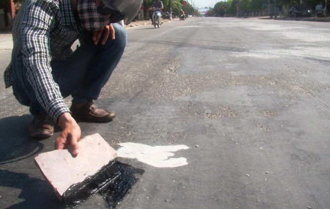 Nhựa chảy loang lỗ trên mặt đường - Ảnh: Văn Định