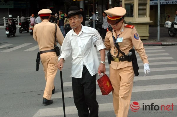 Nữ CSGT đưa người già qua đường.