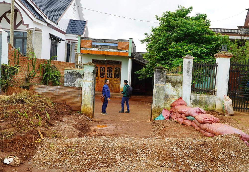 Người dân dùng bao cát, đắp kè chắn trước cổng nhà để ngăn nước. Ảnh: LK.