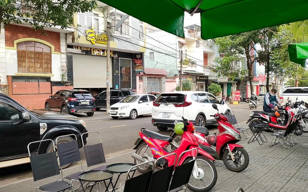 Đường nhỏ nhưng hai bên đường đều có ô tô đỗ.