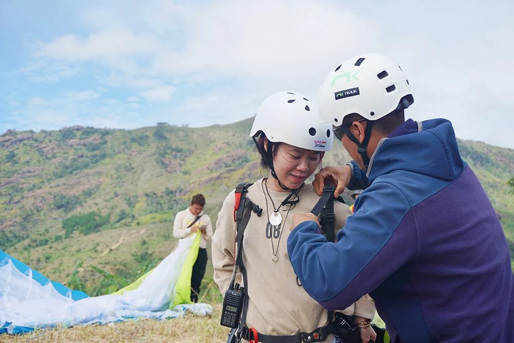 Một nữ du khách từ Đà Nẵng vào Gia Lai để trải nghiệm việc bay dù lươn từ trên đỉnh núi lửa Chư Đăng Ya. Trong ảnh phi công đang kiểm tra công tác an toàn trước lúc bay. CLB Dù lượn Sơn Trà phối hợp với Ban tổ chức thực hiện đóng bảo hiểm cho du khách, đảm bảo bay an toàn.