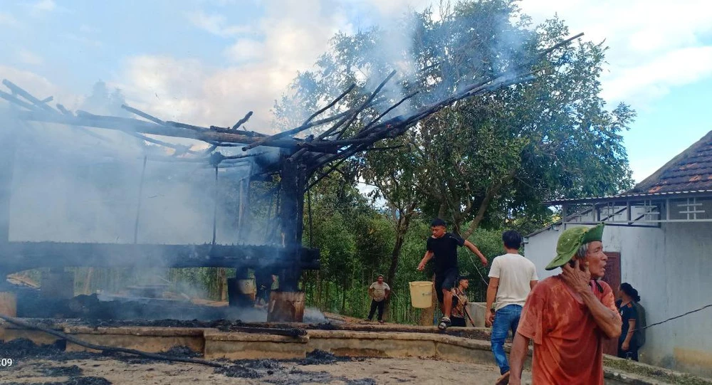 Người dân bất lực trong việc dập tắt đám cháy nhà rông. Ảnh: HL.
