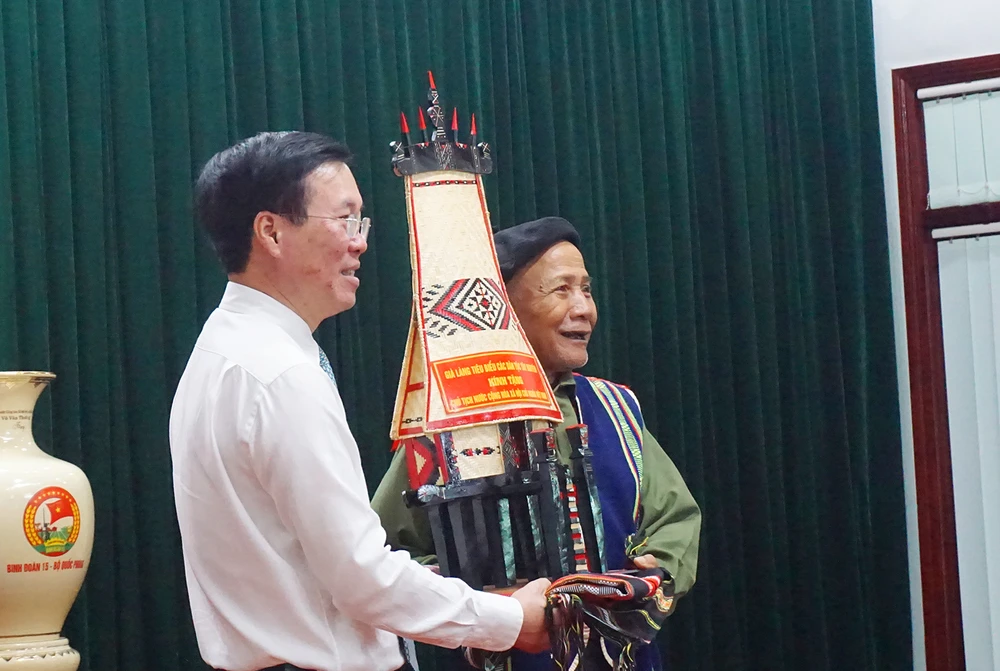 Đại diện các già làng, người uy tín tặng Chủ tịch nước mô hình nhà rông truyền thống. Ảnh: LK.