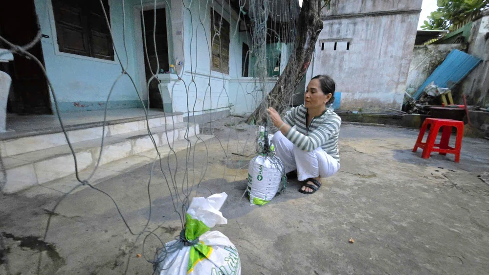 Người dân phường Quy Nhơn Đông dùng bao cát chằn chống nhà cửa, tránh tốc mái nhà khi bão đổ bộ.