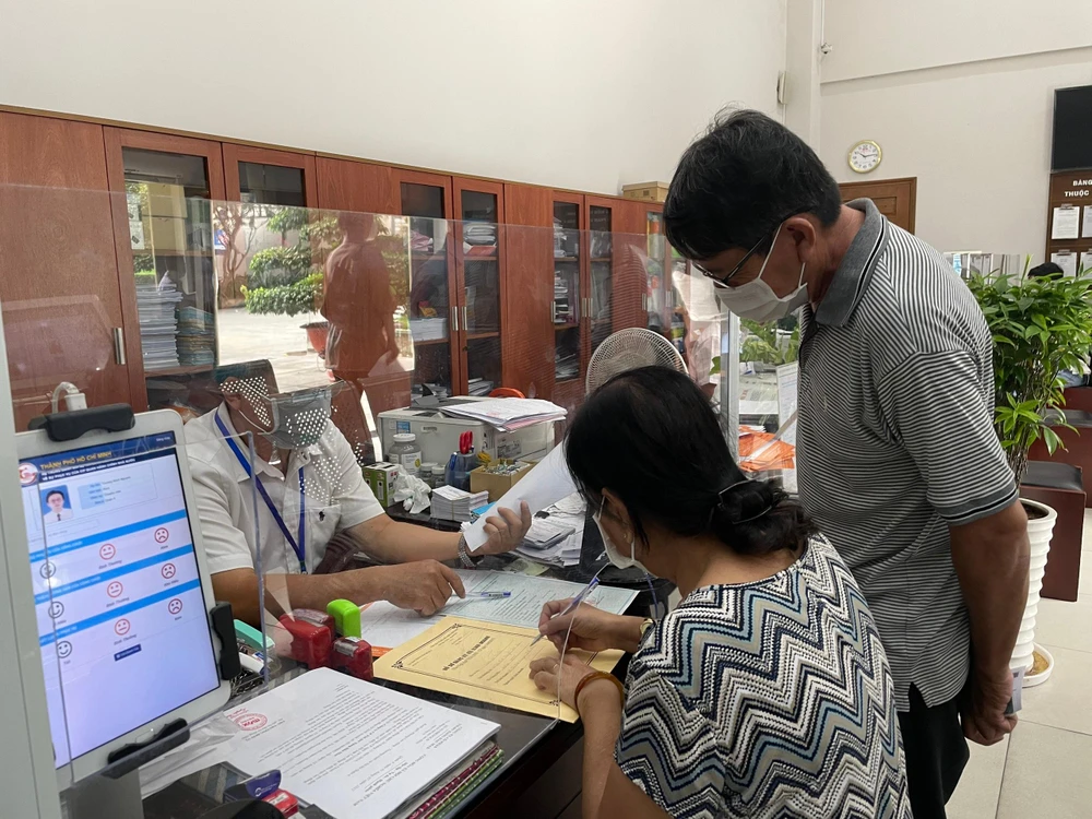 Theo UBND quận 4, có tới hơn 99% người dân hài lòng về giải quyết thủ tục hành chính trong lĩnh vực đất đai, xây dựng. Trong hình là người dân đến giao dịch tại bộ phận một cửa quận 4 sáng 13-7. Ảnh VIỆT HOA