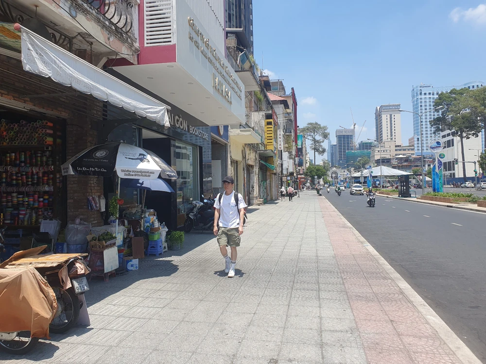 Du khách "đội nắng" trên đường Lê Lợi trưa ngày 26-3. Ảnh KC