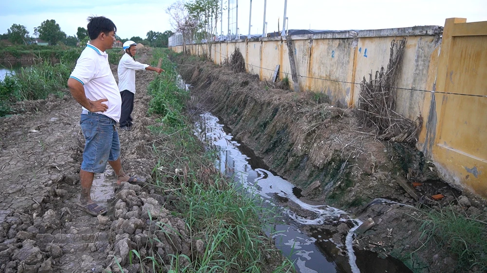 Người dân phát hiện nước thải rác đen ngòm được bơm từ bên trong bãi rác qua khe hở của chân tường xả ra kênh mương đào, nguồn nước thải này chảy thẳng ra sông Hàm Luông. Ảnh ĐÔNG HÀ
