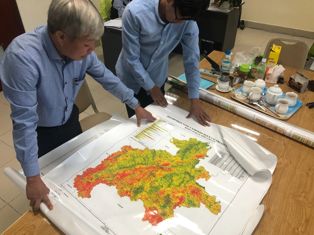 TS Trịnh Xuân Hoà và bản đồ cảnh báo sạt lở. Ảnh TP