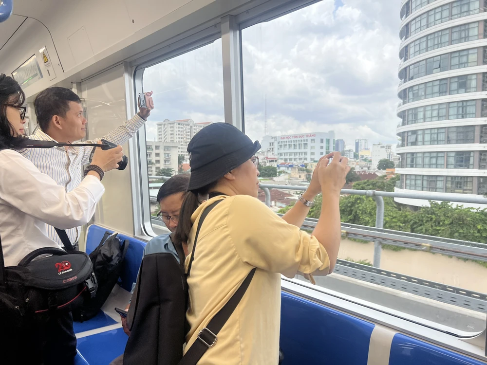 Hành khách chụp ảnh TP từ trên tàu metro số 1. Ảnh TRANG TIẾN Hành khách chụp ảnh TP từ trên tàu metro số 1. Ảnh TRANG TIẾN