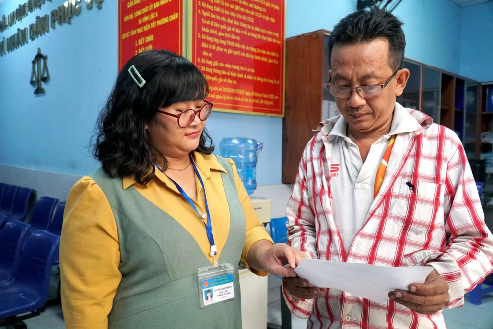 Bà Nguyễn Thị Như An, công chức tư pháp - hộ tịch xã Vĩnh Lộc A, đang tận tình hướng dẫn cho người dân làm các hồ sơ, thủ tục. Ảnh: LÊ THOA