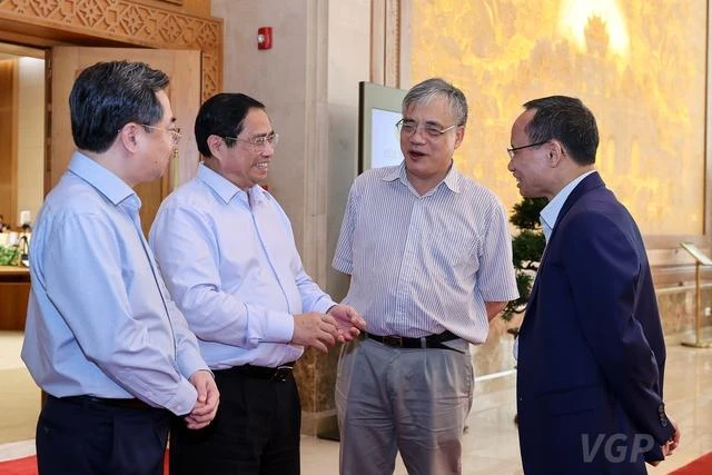 Thủ tướng Phạm Minh Chính trao đổi với các chuyên gia bên hành lang hội nghị. Ảnh: VGP