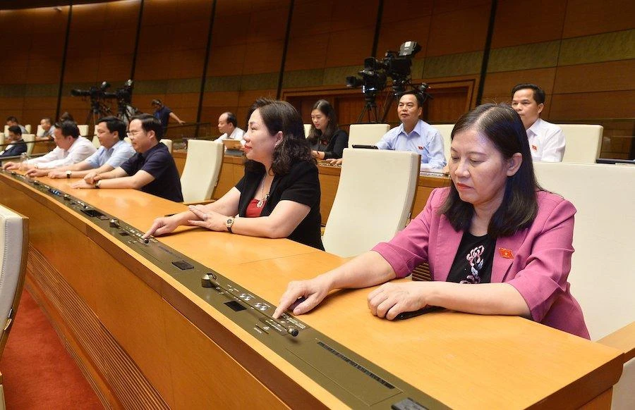 Đại biểu Quốc hội bấm nút thông qua Luật Phòng, chống bạo lực gia đình (sửa đổi). Ảnh: PHẠM THẮNG