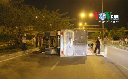 Xe tải đâm bật gốc cây xanh, lật ngang đường ảnh 1