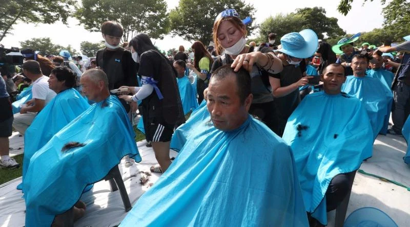 Người dân tại Seongju, Hàn Quốc hôm 15-8 cùng cạo đầu trong một cuộc biểu tình phản đối kế hoạch triển khai THAAD. Ảnh: Reuters