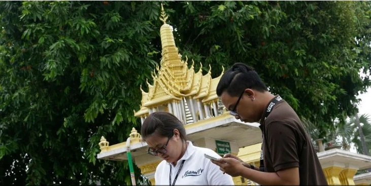 Các phóng viên Thái Lan chơi Pokemon Go trước một tòa nhà . Ảnh: AP