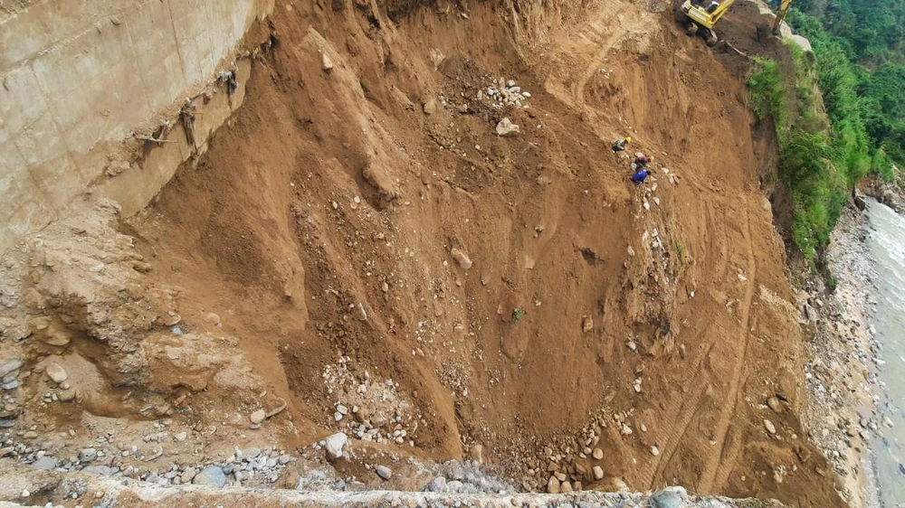 Đường dẫn cầu Khỉ bị sạt lở, người dân mạo hiểm leo lên thành cầu để ra ngoài. Ảnh: CTV