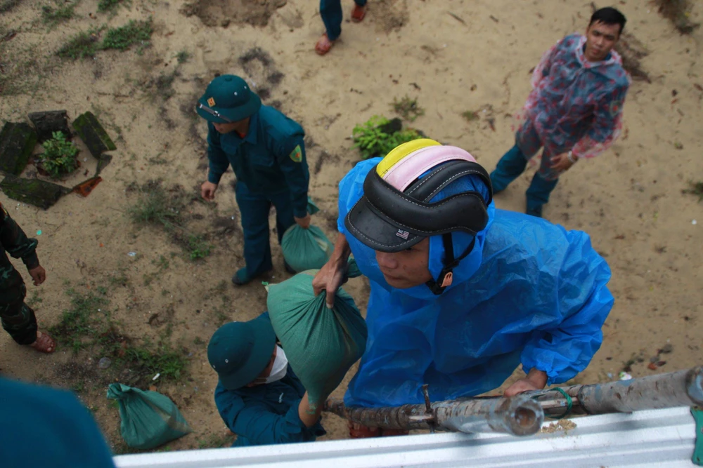 Dân quân tự vệ tham gia giúp người dân chằng nhà.