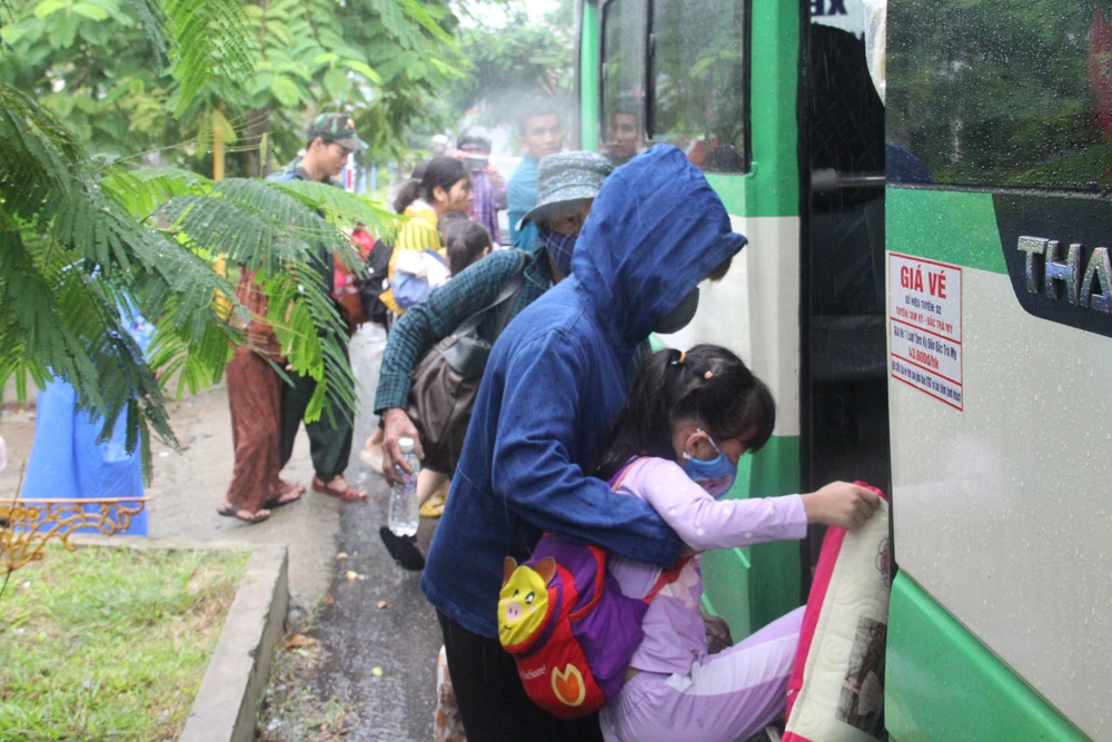 Người dân di chuyển lên xe. Ảnh: THANH NHẬT