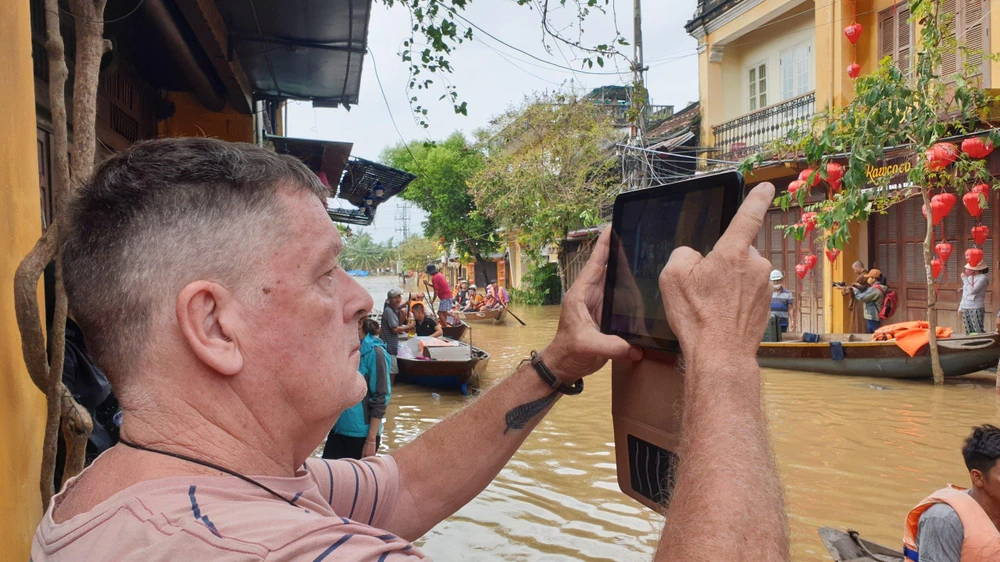 Du khách nước ngoài thích thú ghi lại khoảnh khắc phố cổ ngập lụt.