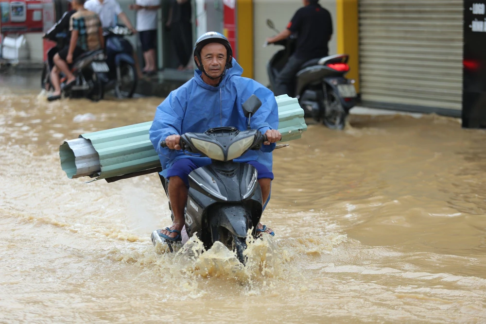 Nước ngập hơn nữa bánh xe. Ảnh: TN