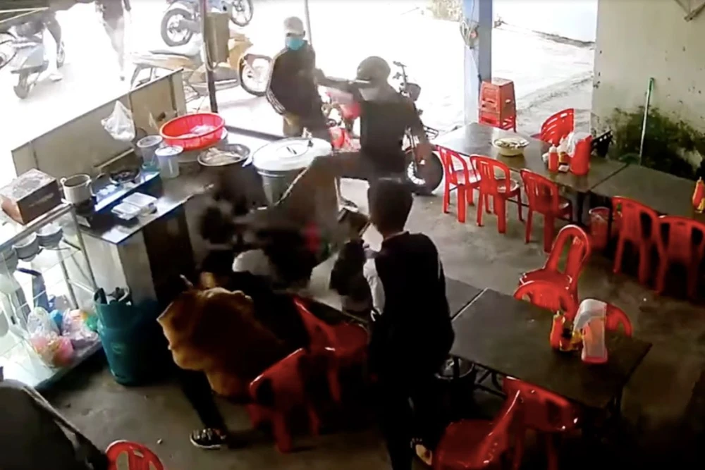 Nhóm người bịt khẩu trang, xông vào quán nước đánh hai nam sinh. Ảnh chụp từ clip.
