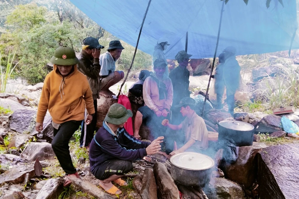 Người dân dựng lều tạm cùng lực lượng chức năng tìm kiếm tung tích nạn nhân. Ảnh: TN