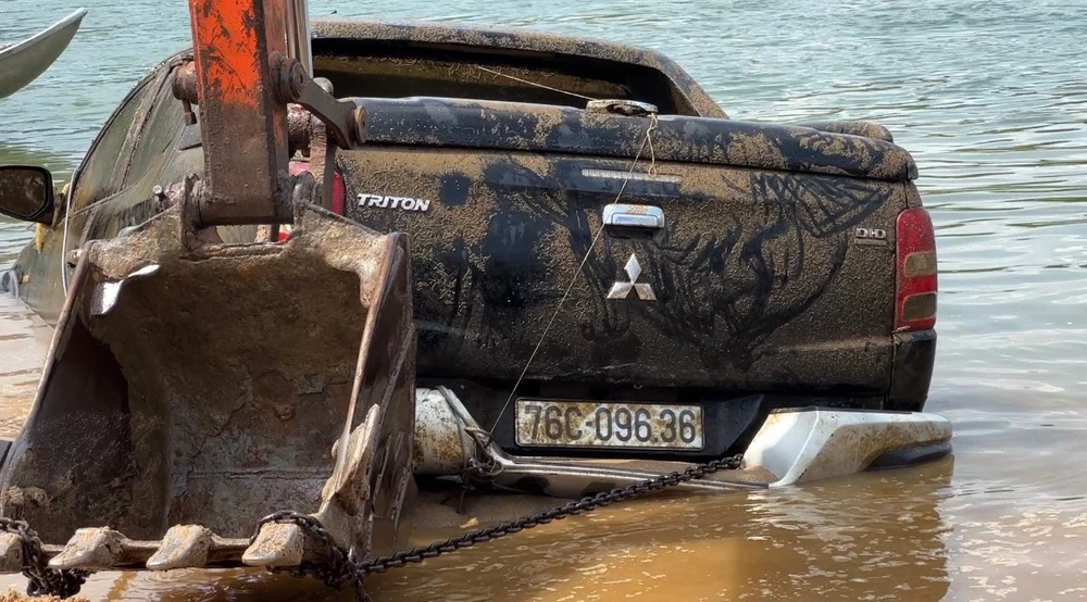 Chiếc ô tô được trục vớt lên bờ. Ảnh: CA
