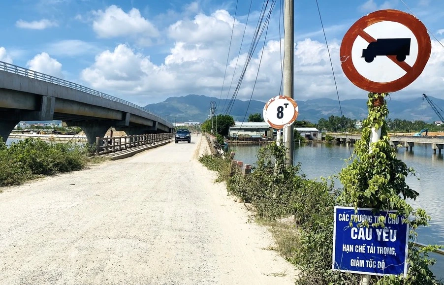 Cơ quan chức năng cắm biển hạn chế tải trọng, tốc độ trên cầu cũ. Ảnh: TN