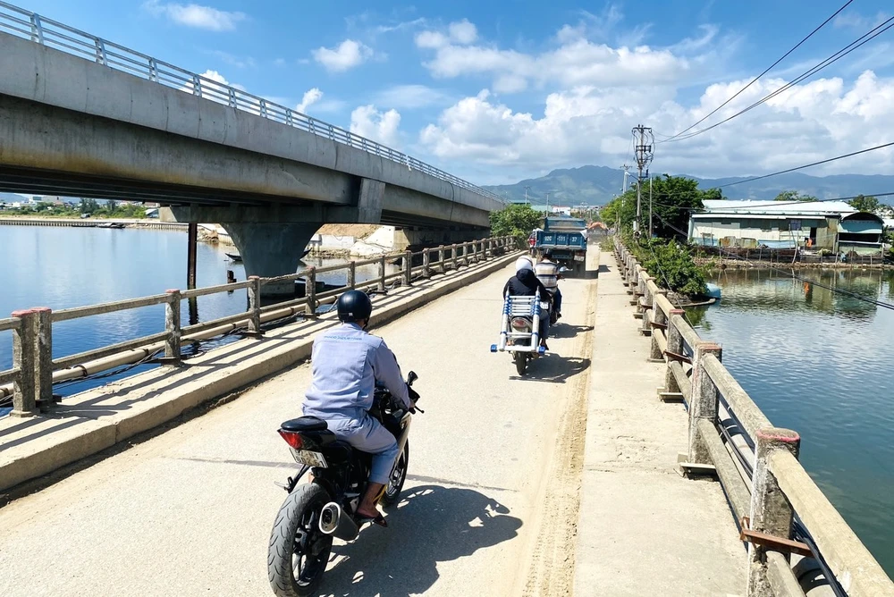 Hàng ngày, người dân qua lại trên cây cầu cũ ọp ẹp, xuống cấp. Ảnh: TN