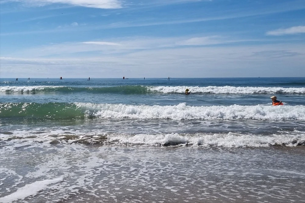 Phó phòng CSGT và Giám đốc Sở Xây dựng tỉnh Quảng Ngãi tắm ở biển Mỹ Khê, kịp thời cứu 3 mẹ con bị sóng cuốn. Ảnh: CTV