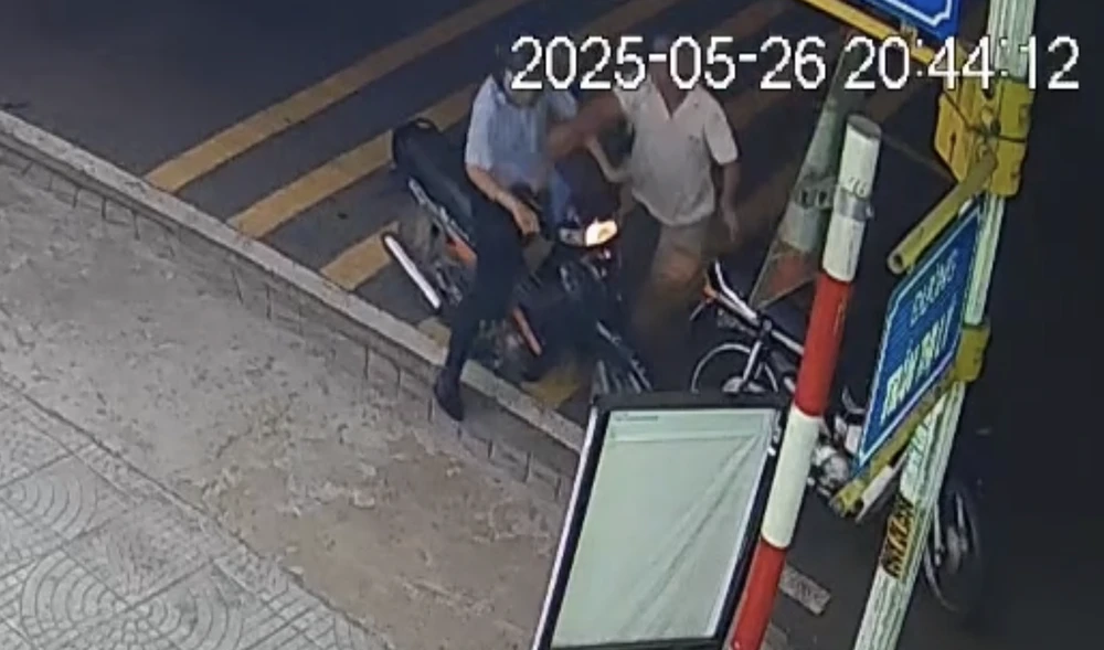 Thầy giáo bị người đàn ông chặn xe tán gạch vào đầu, đánh tới tấp. Ảnh cắt từ clip.