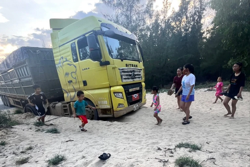 Tài xế người Lào lái xe chở quặng lạc ra biển, người dân xúm vào giải cứu. Ảnh: FB Phuc Thanh Pham.