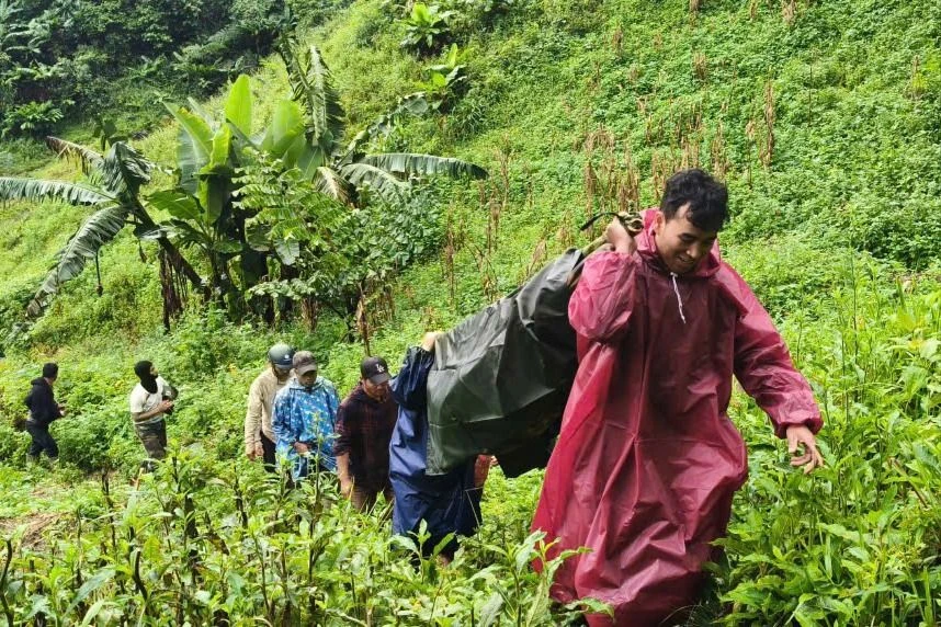 Bộ đội, công an khiêng cụ bà người Lào vượt 5km đường rừng về nhà. Ảnh: AN