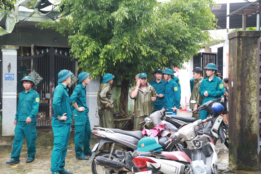 Dân quân phường Hoà khánh gõ cửa từng nhà, giúp người dân kê cao đồ đạc. Ảnh: Thanh Nhật