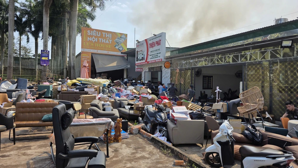 Người đi đường giúp khiêng hết hàng hóa ở siêu thị nội thất ra ngoài để tránh cháy lan