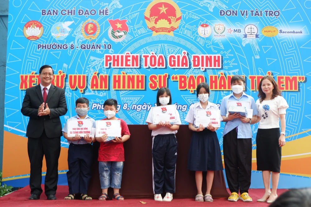 Ông Nguyễn Văn Thành, Phó chủ tịch UBND phường 8 và mạnh thường quân trao tặng phần học bổng cho học sinh thuộc hộ có hoàn cảnh khó khăn. Ảnh: TRÚC PHƯƠNG