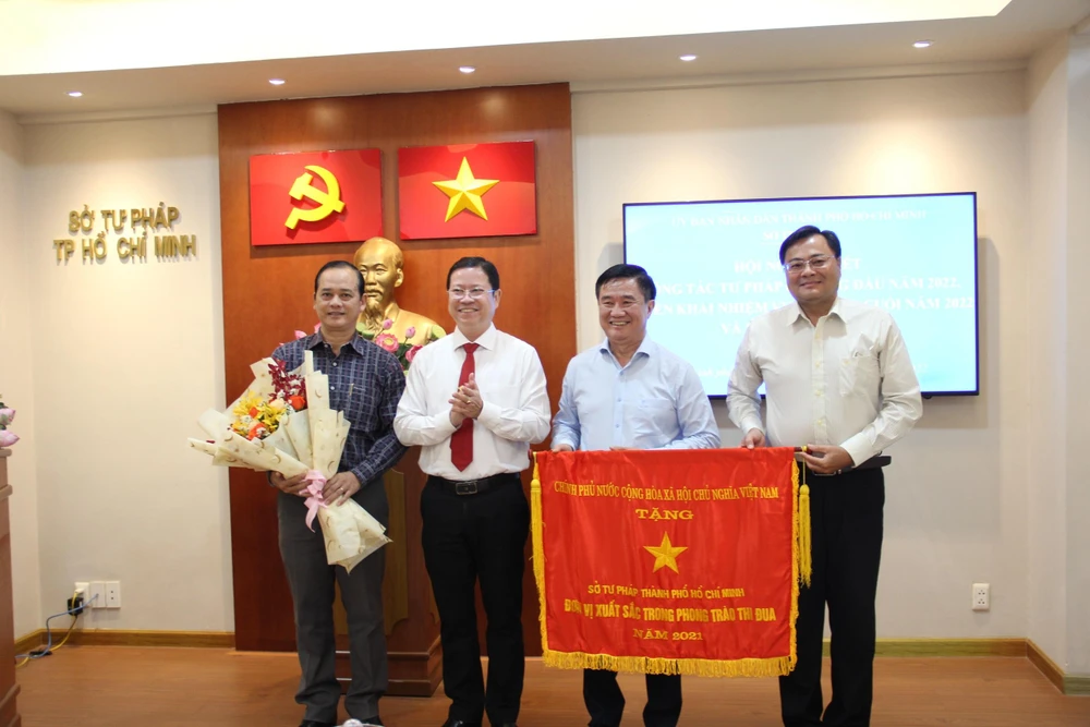 Nguyễn Hoàng Hưng, Phó trưởng Ban Thi đua – Khen thưởng TP.HCM trao tặng Cờ thi đua của Chính phủ cho Sở Tư Pháp TP.HCM, đơn vị xuất sắc trong phong trào thi đua năm 2021. Ảnh: TRÚC PHƯƠNG