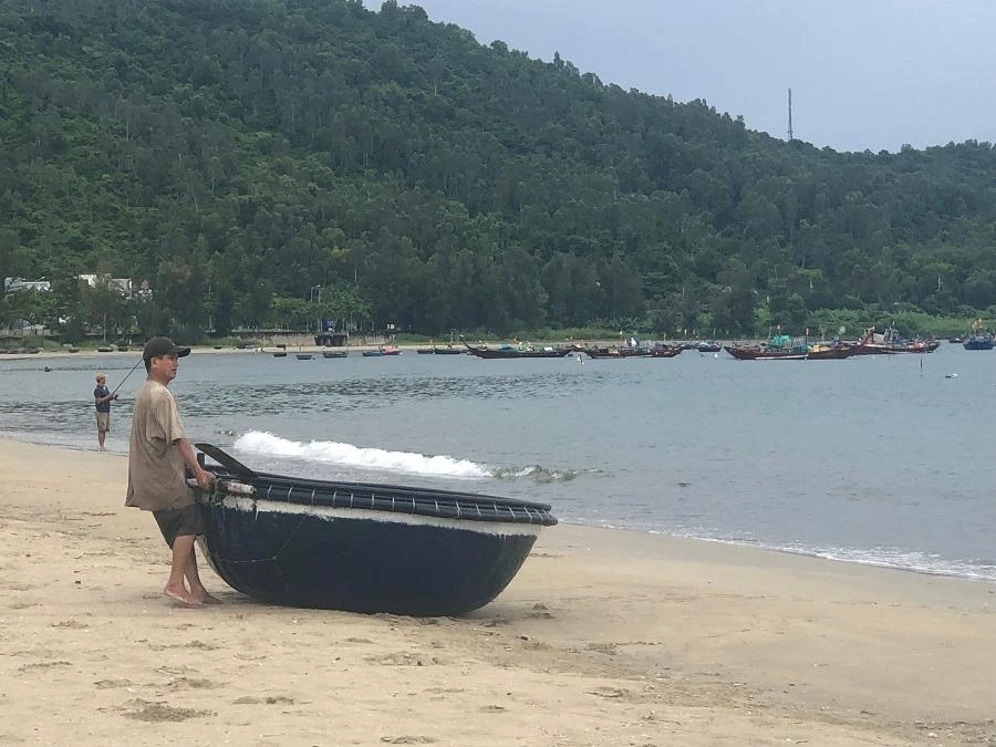 Ngư dân kéo thúng lên bờ trước khi bão đổ bộ-Ảnh: NGÔ QUANG