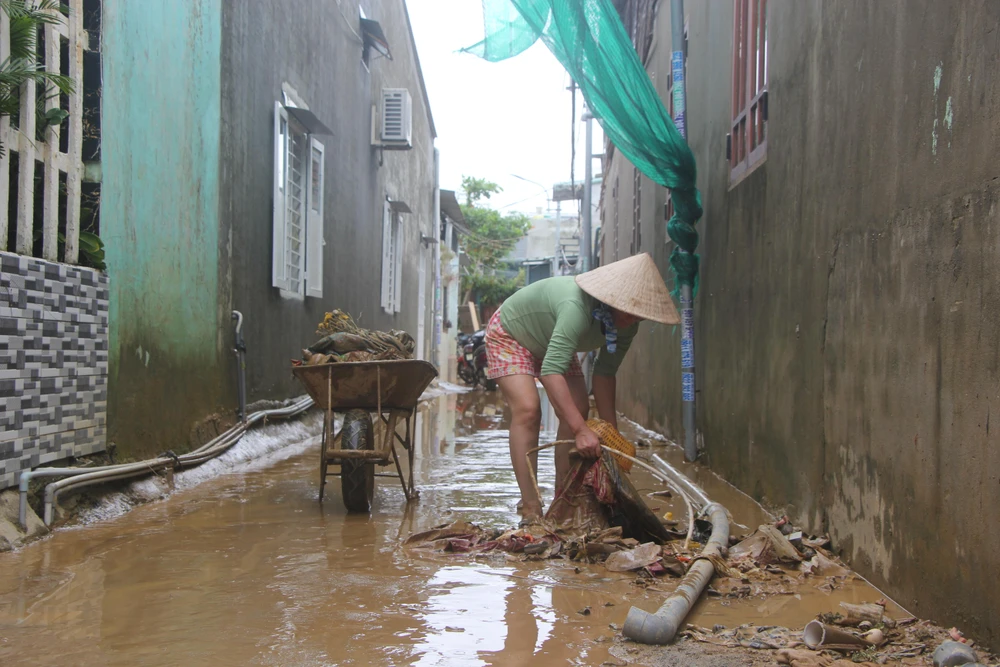 Người dân ở phường Hoà Khánh Nam dọn dẹp sau trận lụt. Ảnh: NGÔ QUANG