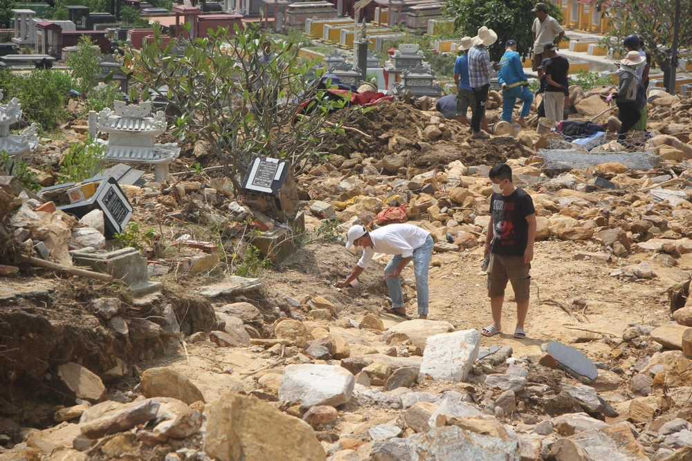 Người dân đi tìm các phần mộ bị chôn vùi trong đất đá-Ảnh: NGÔ QUANG