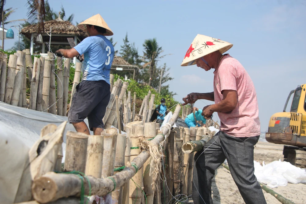 Người dân kinh doanh nhà hàng, khách sạn tại biển An Bàng đang gia cố lại đoạn kè. Ảnh: NGÔ QUANG