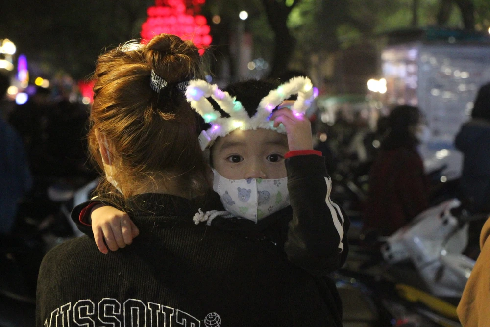 Những em bé được cha mẹ đưa cùng ra phố để đón năm mới.